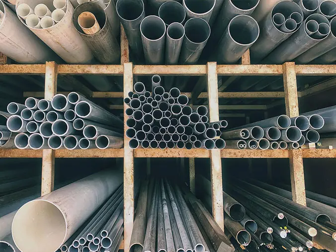 PVC anbd steep plumbing pipes on a shelf in a plumbing supply warehouse